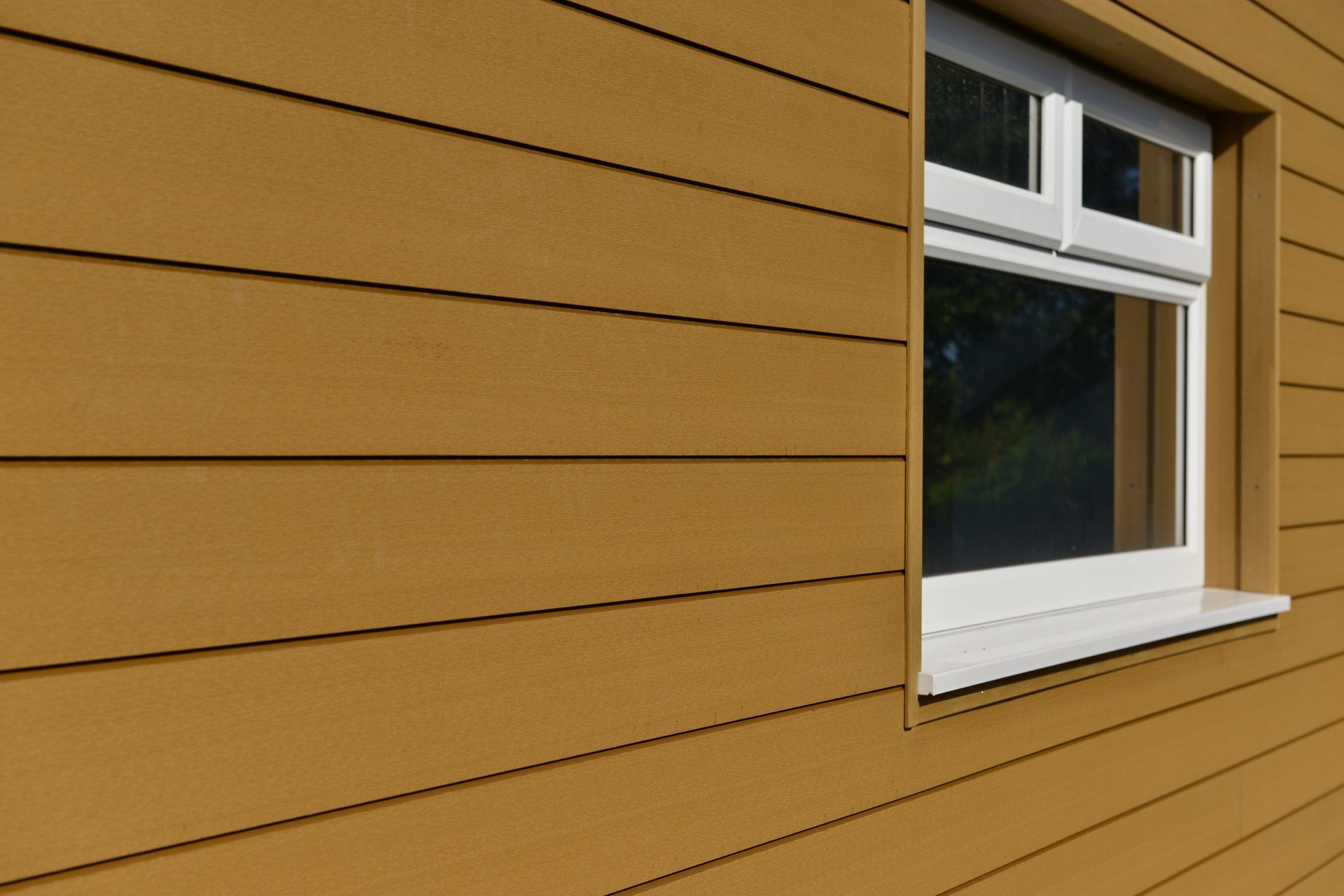 A yellow house with a white window on the side