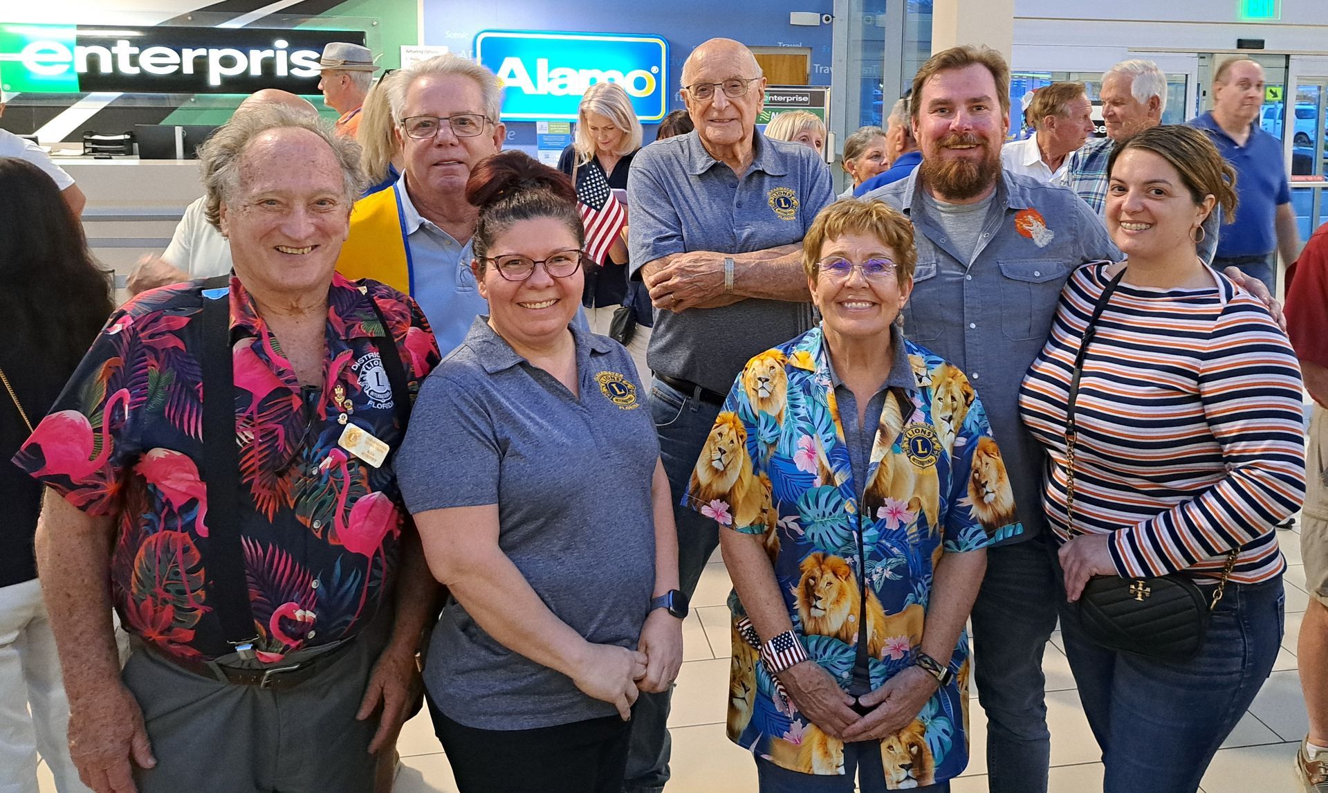 A group of people are posing for a picture in front of a sign that says enterprise.