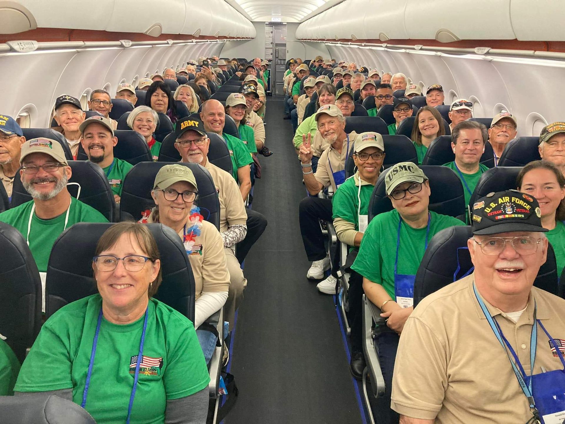 A large group of people are sitting on a plane.