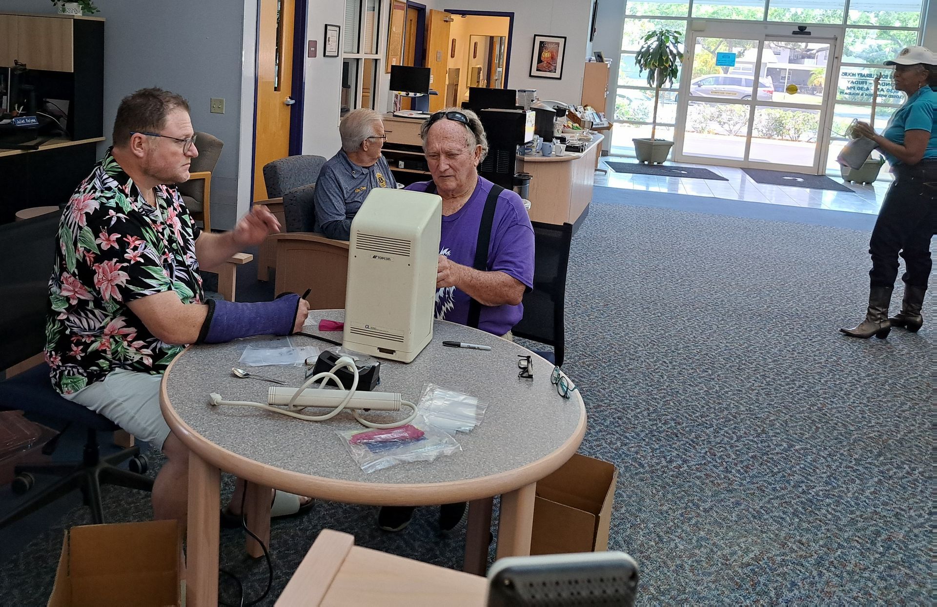 A group of people are sitting around a table working on a computer