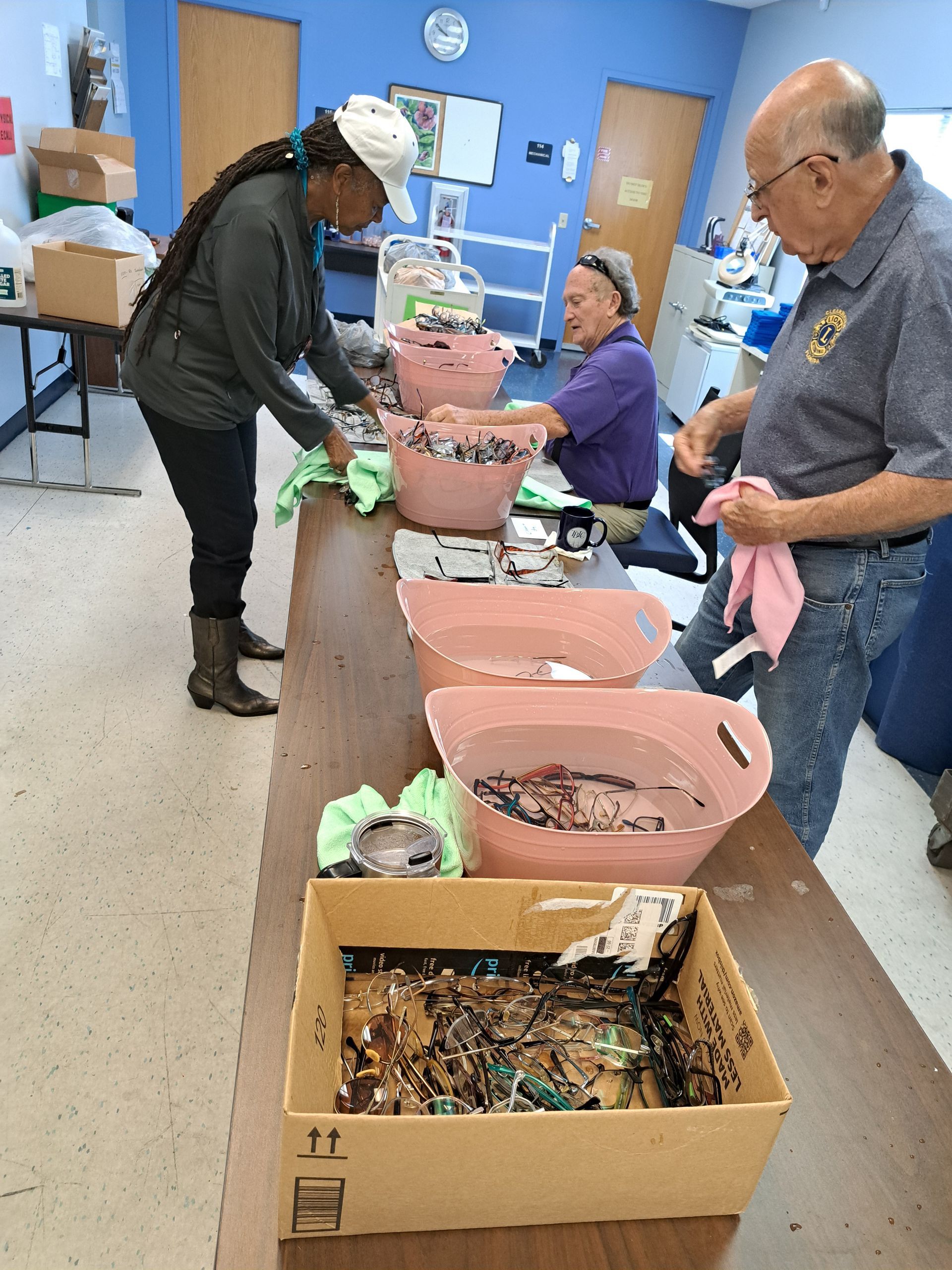 A group of people are standing around a table with bowls of food on it