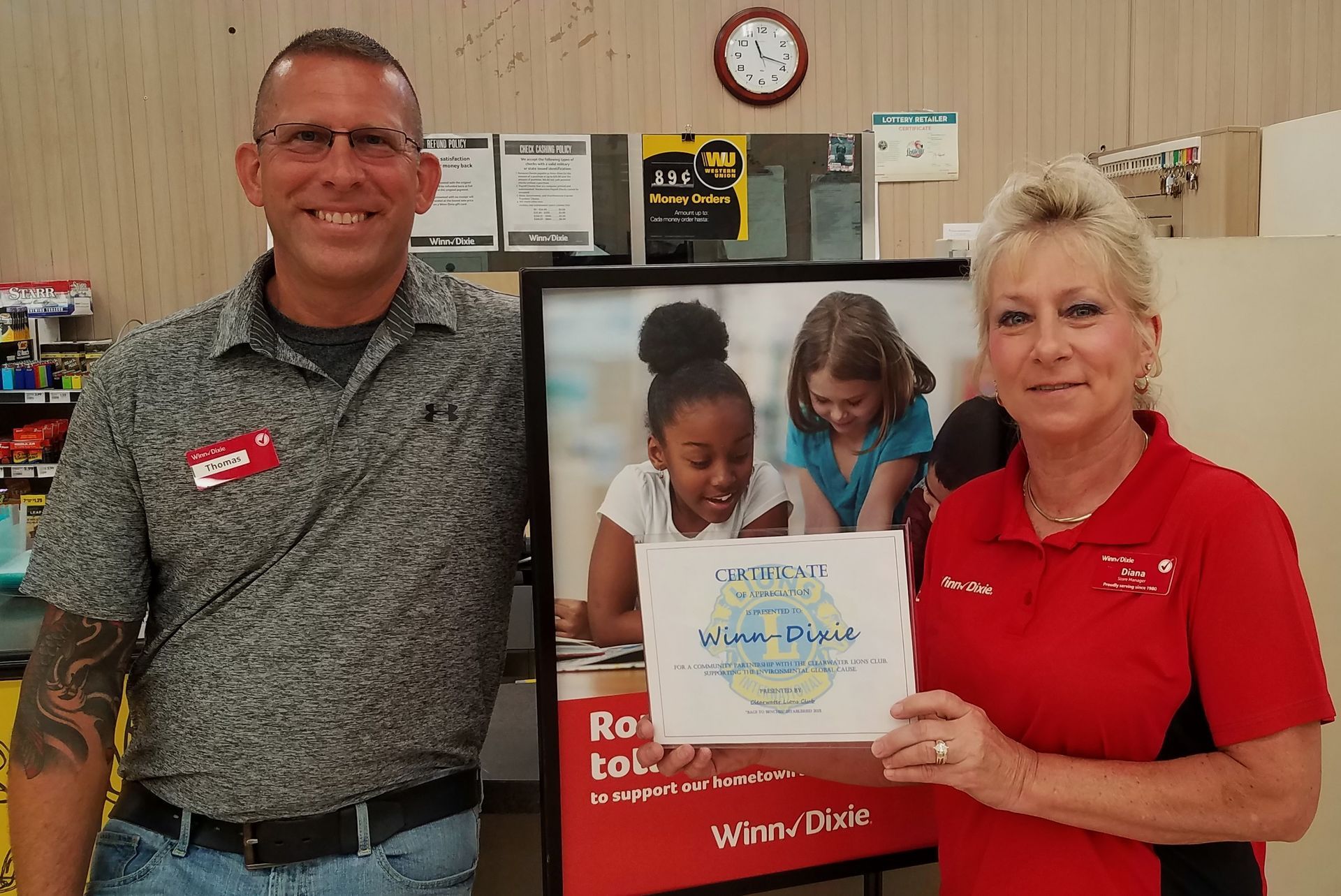A man and a woman standing next to each other holding a sign