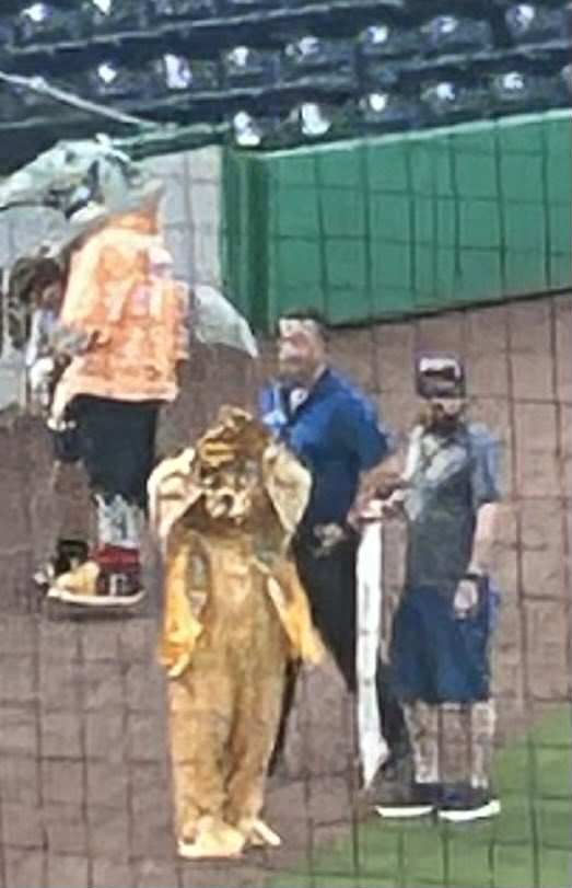 A group of people standing next to each other on a baseball field.