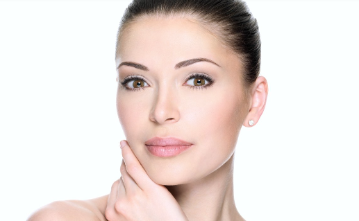 A close up of a woman 's face with her hand on her chin.