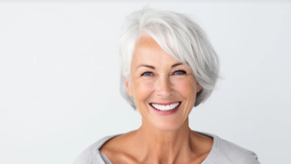 An older woman with gray hair is smiling for the camera.