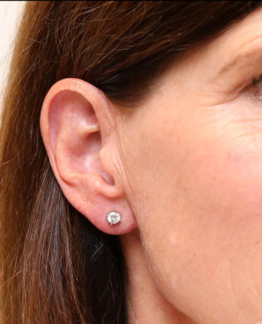 A close up of a woman 's ear with stud earrings