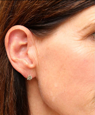 A close up of a woman 's ear with a pair of earrings