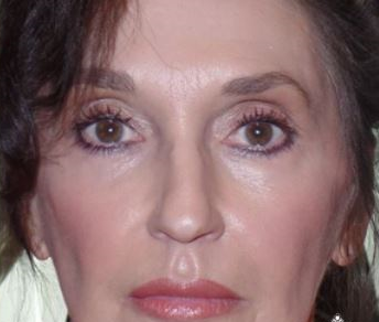 A close up of a woman 's face with a serious look on her face.