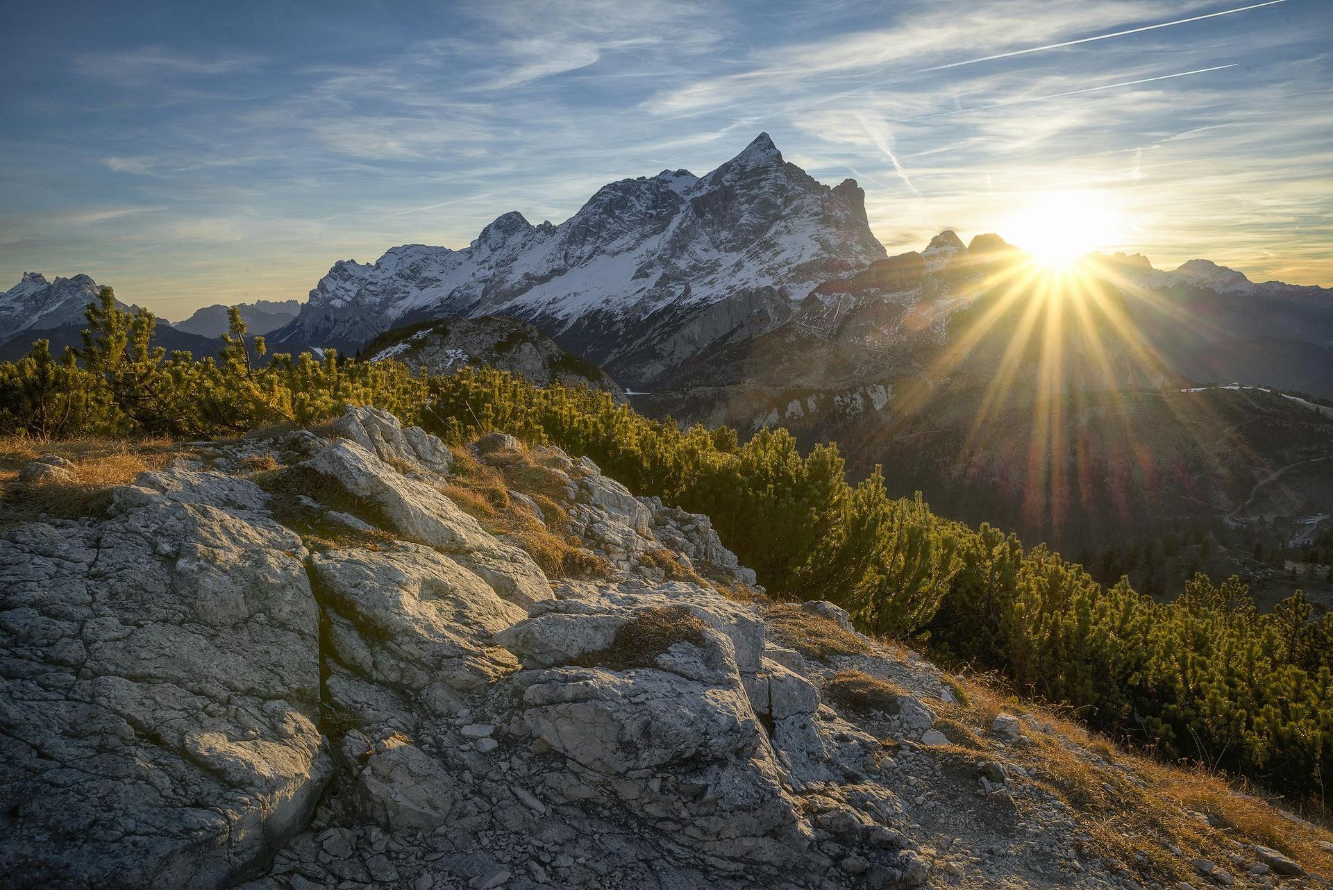 Blick auf eine Bergkette, hinter der die Sonne untergeht.