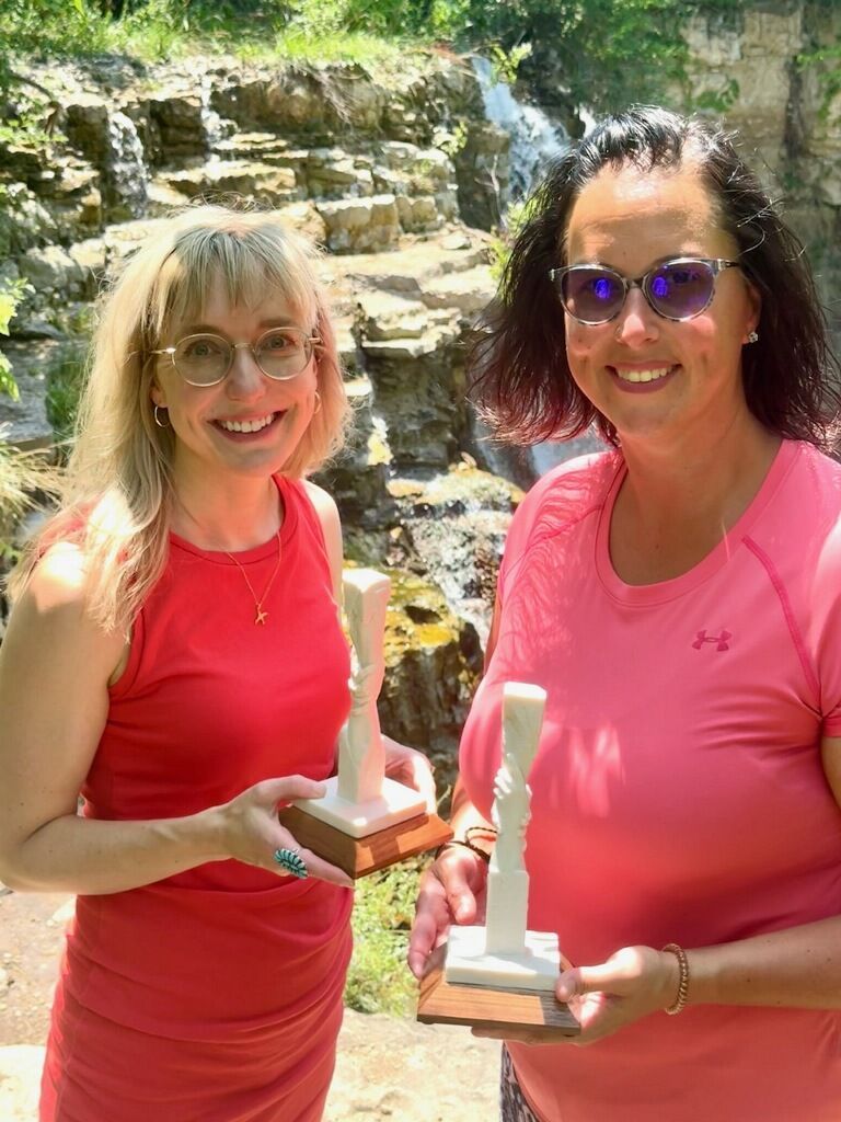 Two woman holding the Faces of Responsibility Award