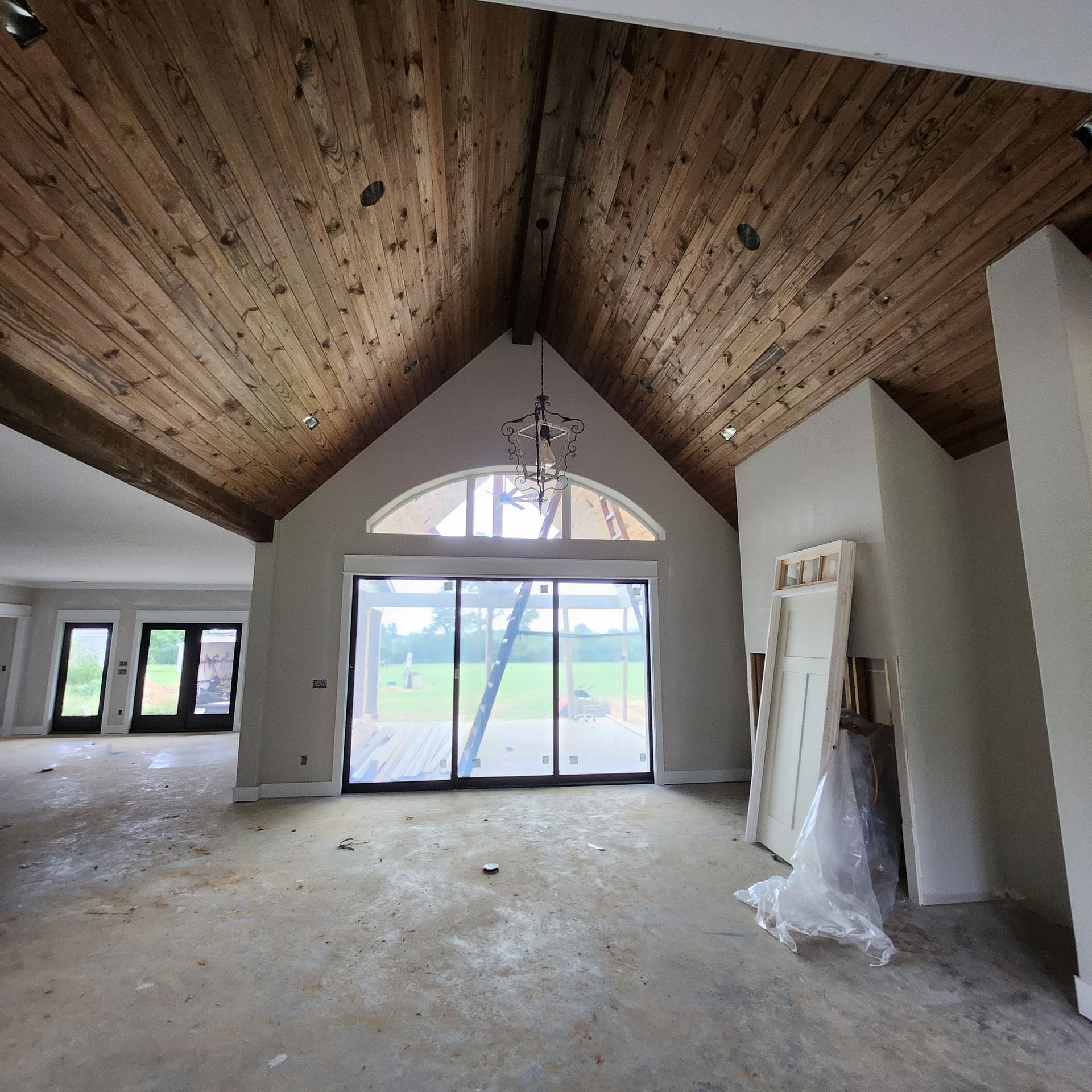 A large room with a vaulted ceiling and sliding glass doors