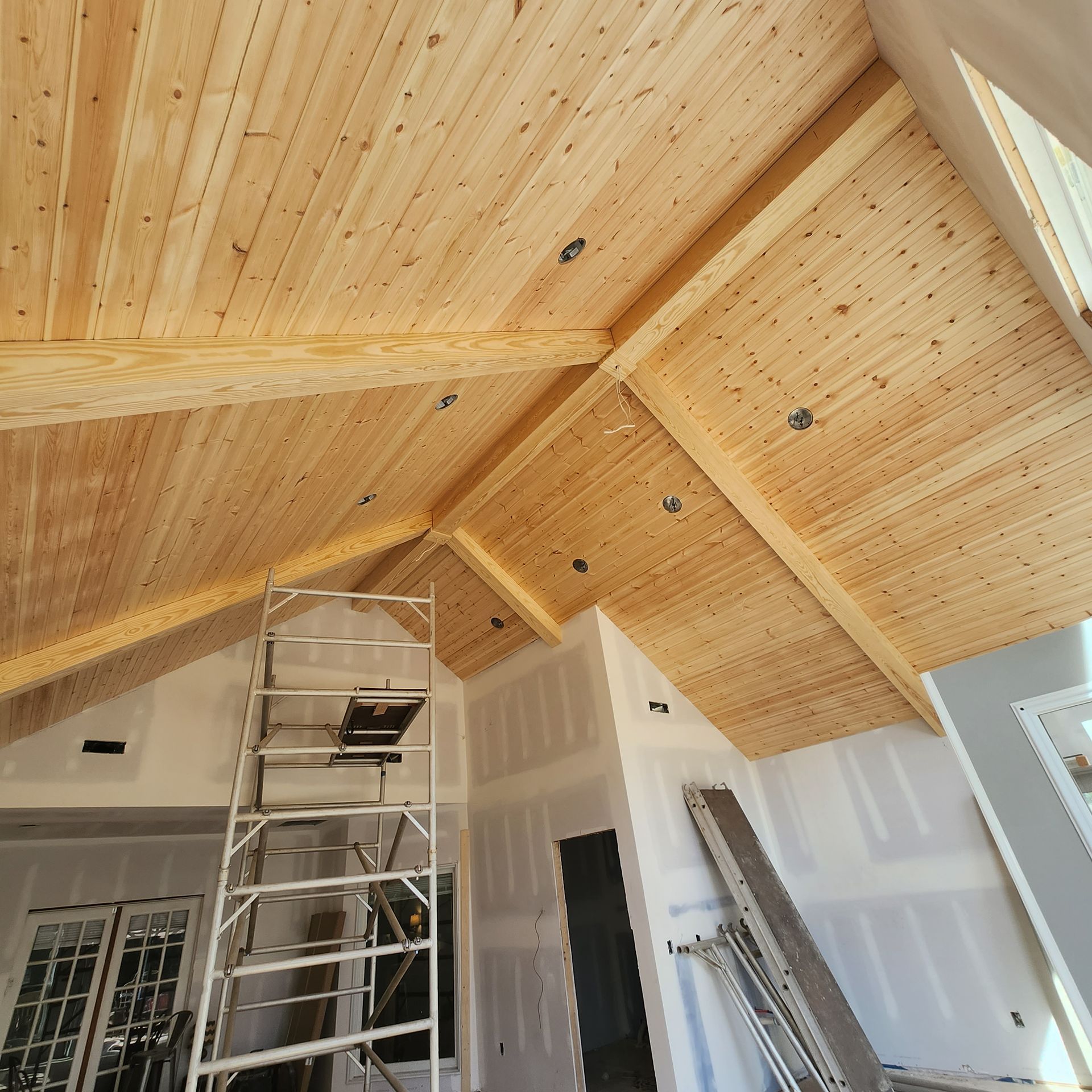 A room with a wooden ceiling and a ladder