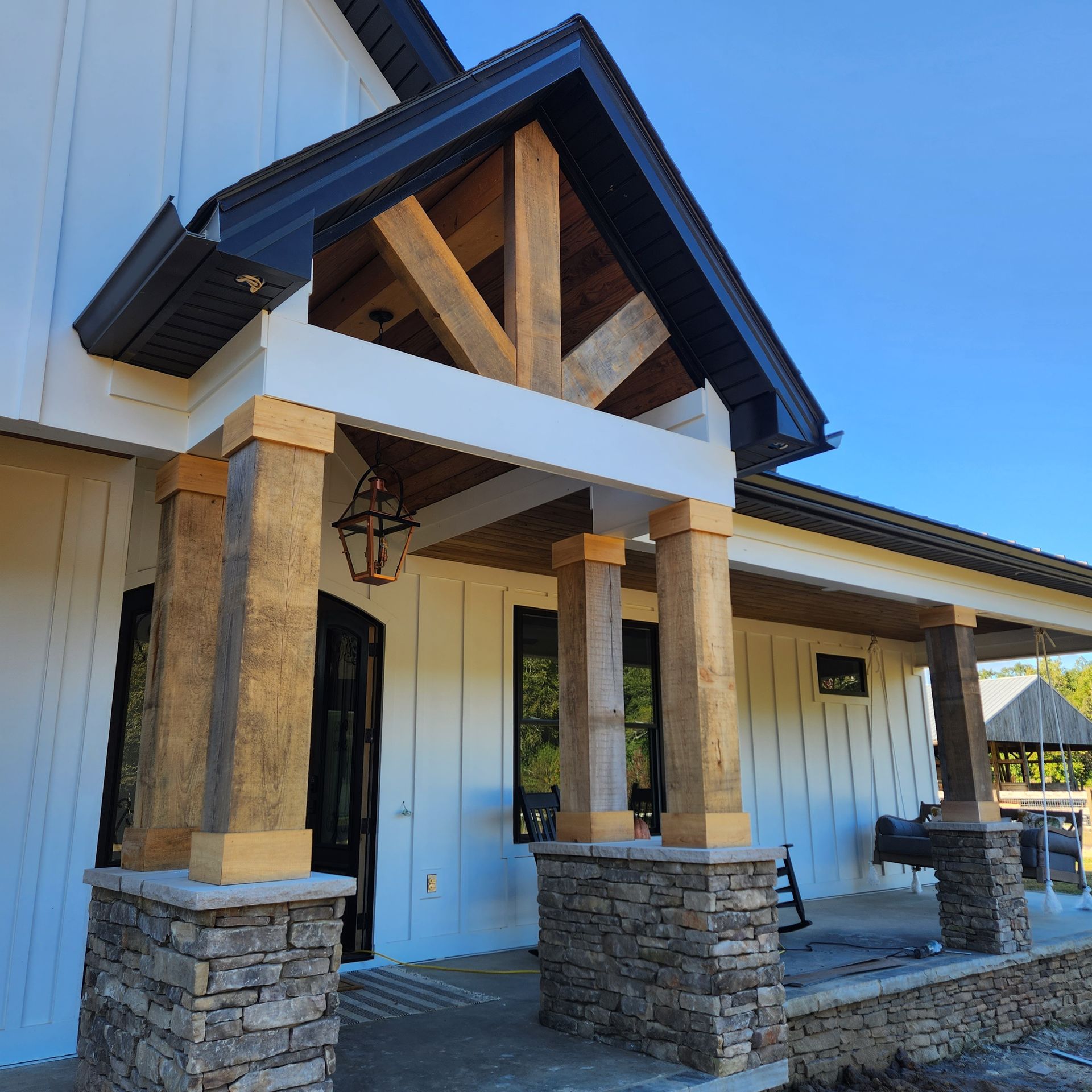 A white house with a porch and stone pillars