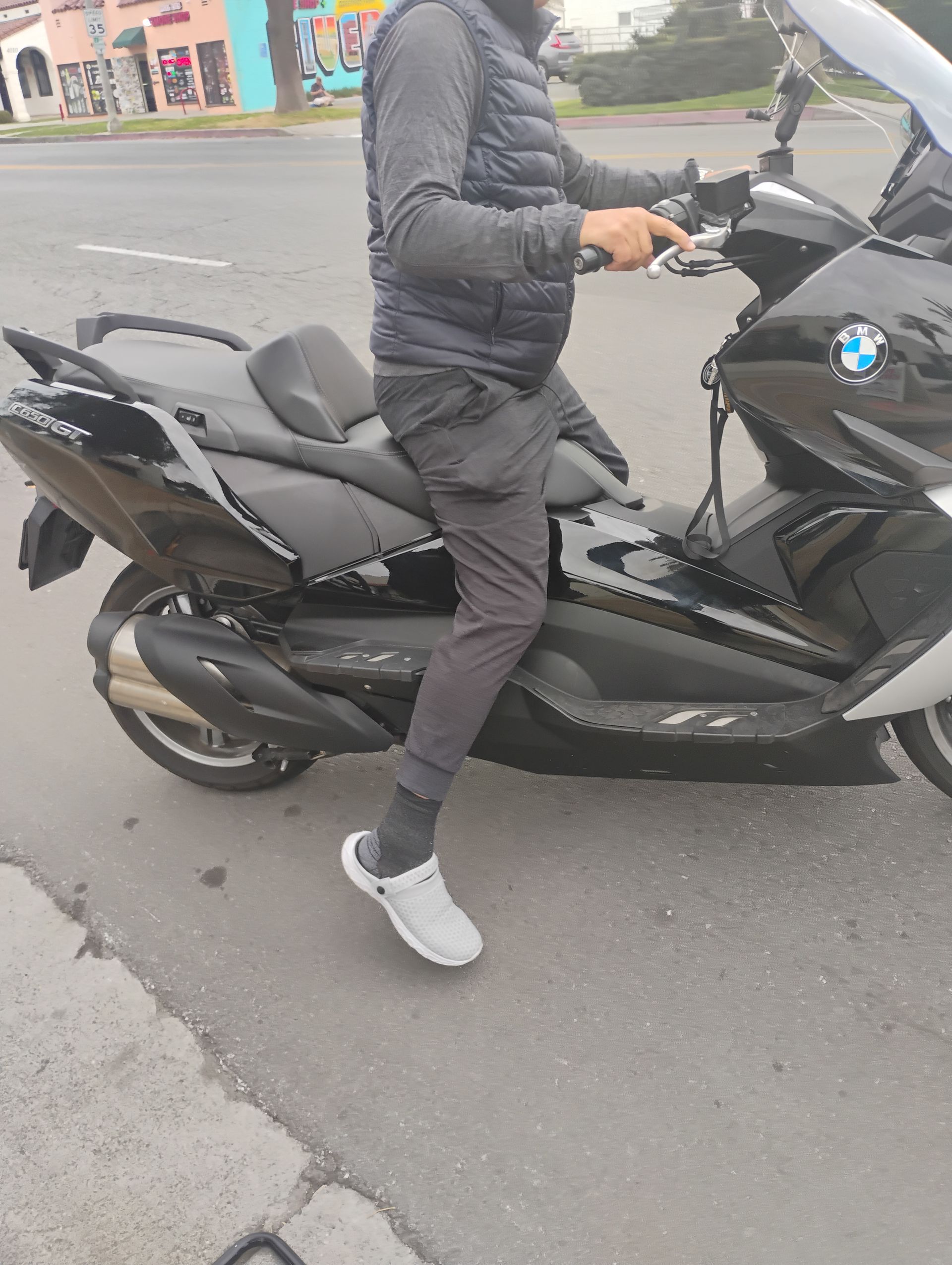 A man is riding a motorcycle on the side of the road.