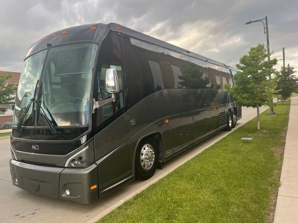 Gray Motor Coach on the curb
