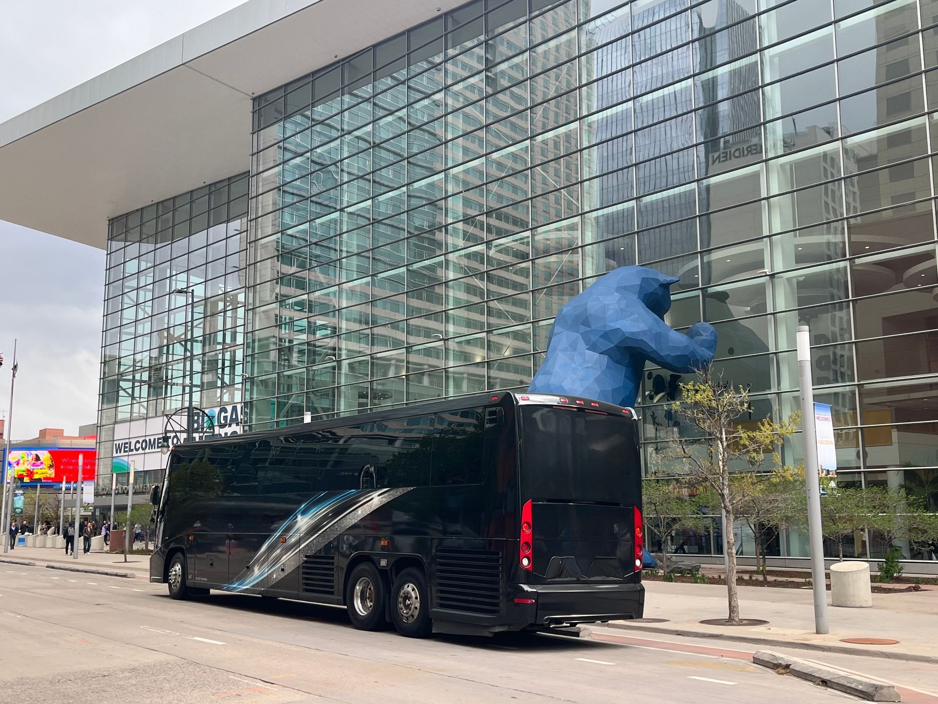 Motor coach delivering corporate representatives to the Colorado Convention Center showing the famous blue bear