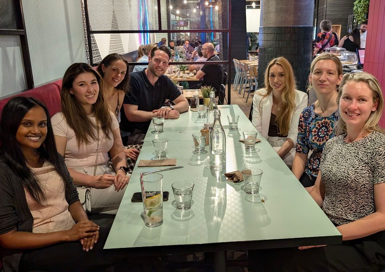 A group of people are sitting at a long table in a restaurant.