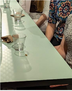 A group of people are sitting at a table with glasses on it