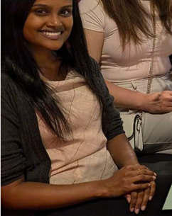 A woman is smiling while sitting next to another woman