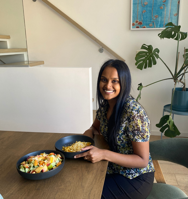A woman is sitting at a table with two bowls of food