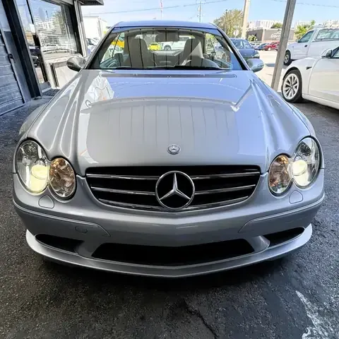 A silver Mercedes-Benz car parked on a paved lot, viewed directly from the front.
