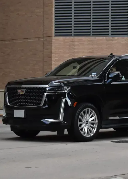 A silver Toyota Camry sedan parked on an asphalt road during a sunset.