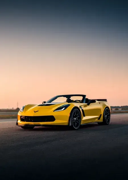 A silver Toyota Camry sedan parked on an asphalt road during a sunset.