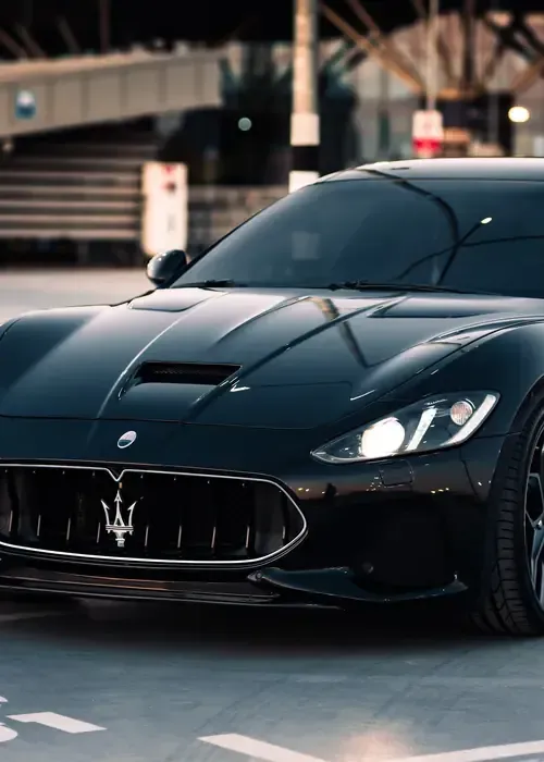 A white Land Rover Range Rover Velar parked outdoors against a grey wall with black wheels and grille.