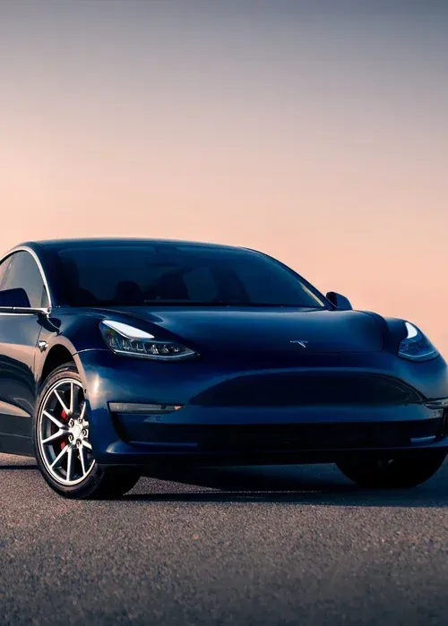 A silver Toyota Camry sedan parked on an asphalt road during a sunset.