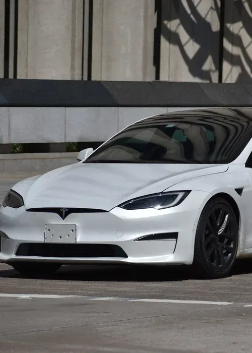 A silver Toyota Tacoma truck driving on a paved road with a large, misty mountain in the background.