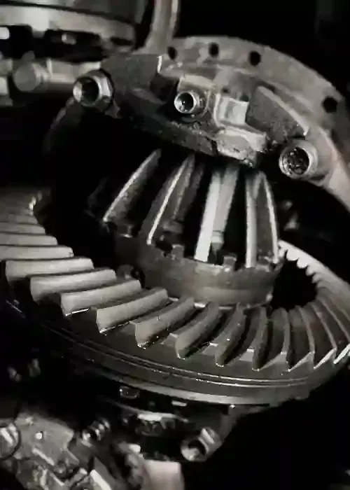 Close-up of metal gears and a differential assembly in grayscale.
