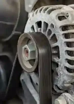 Close-up of a serpentine belt on an alternator pulley in an engine compartment
