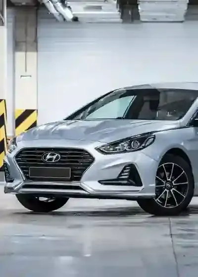 Silver Hyundai sedan parked in an indoor garage, front view near a striped pillar