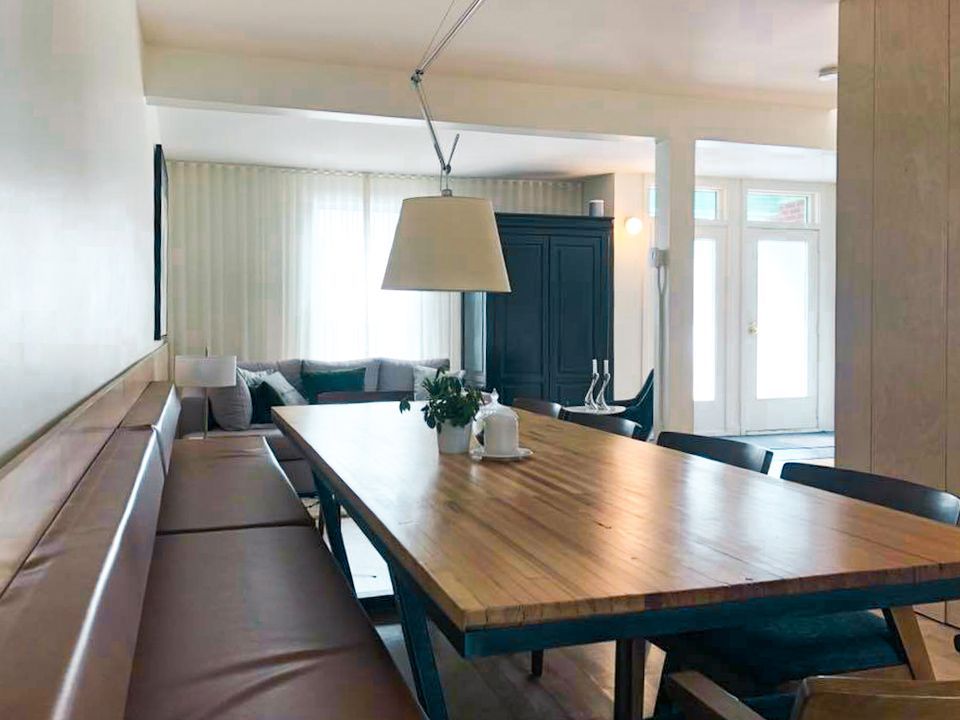 Il y a une longue table en bois au milieu de la pièce.