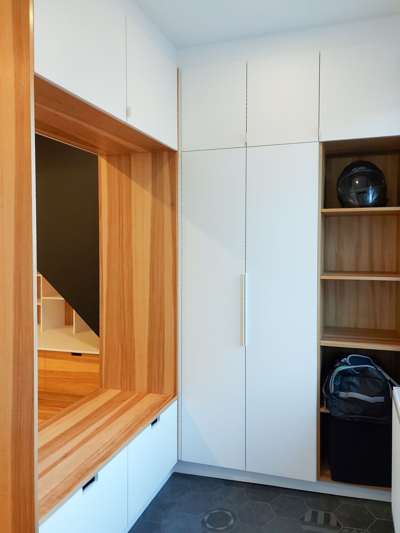 Une pièce avec des armoires blanches et une fenêtre en bois