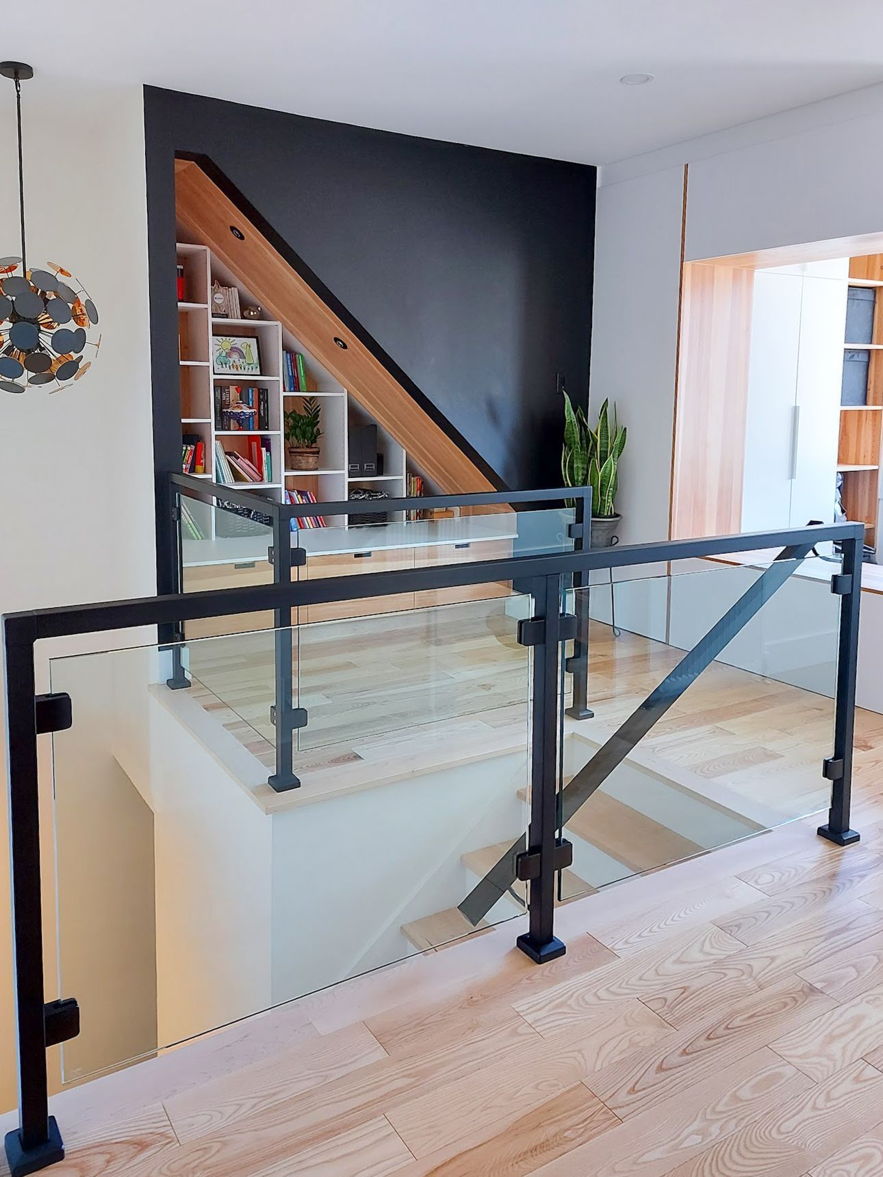 Un escalier avec une rampe en verre et une rampe noire