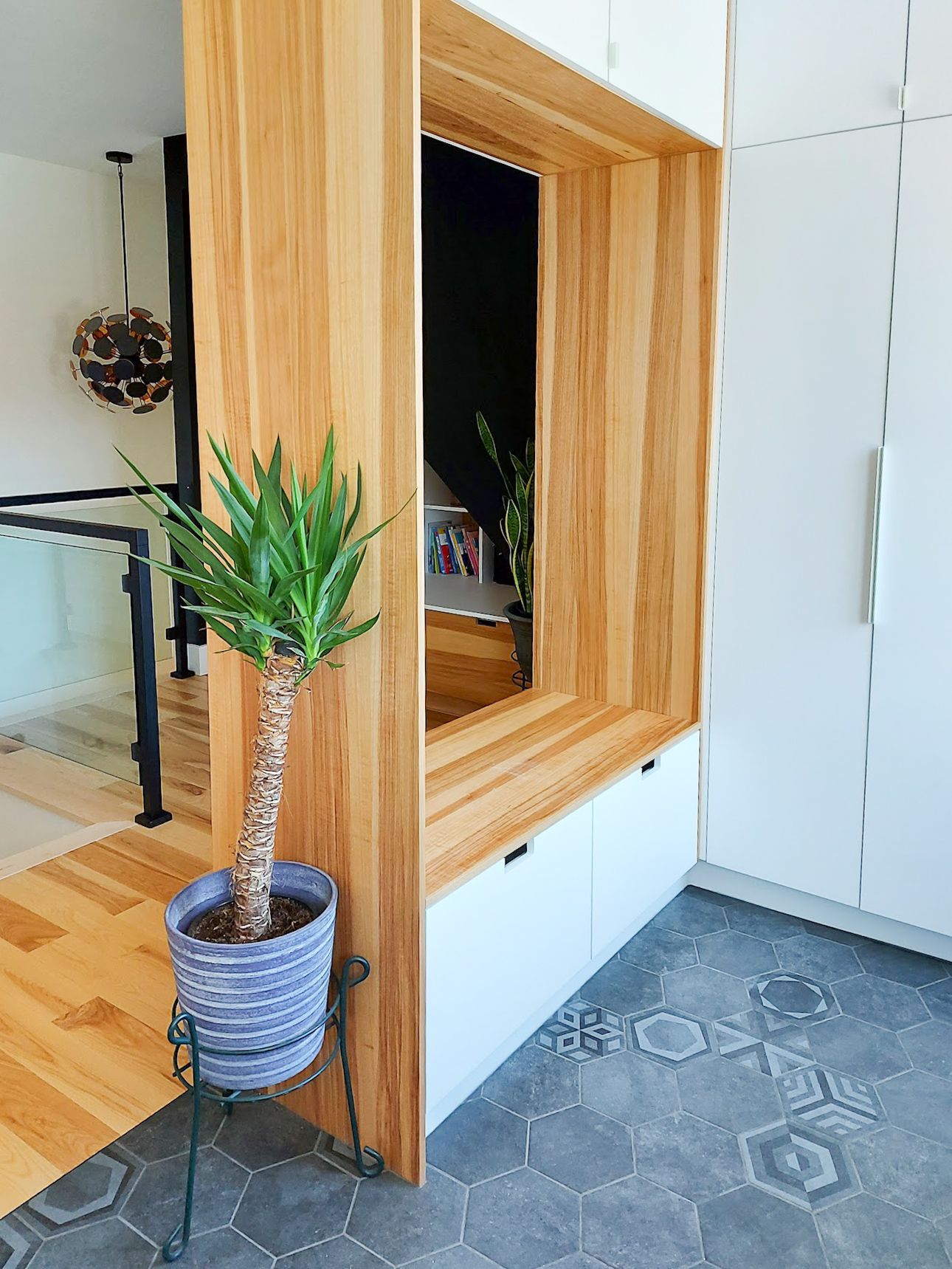 Une plante en pot est posée à côté d'un mur en bois dans une pièce.