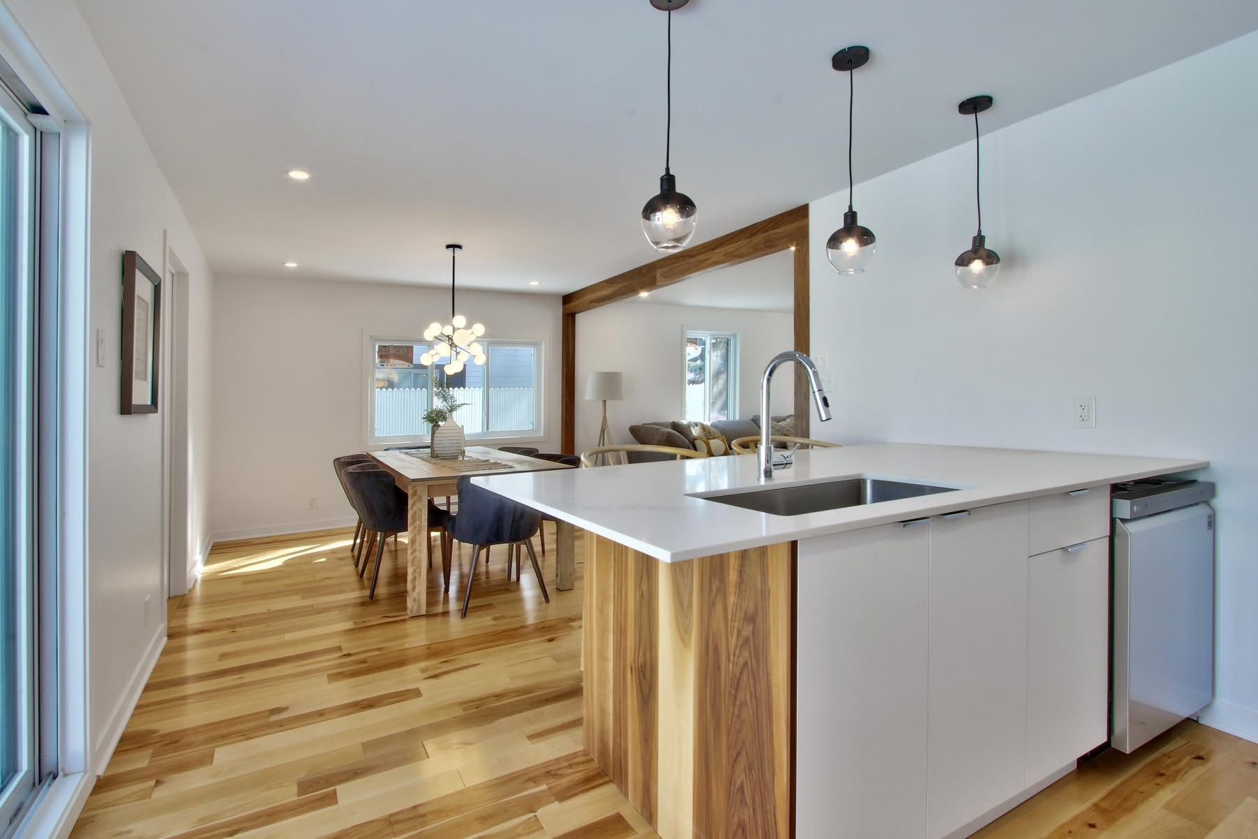 Une cuisine avec un grand îlot, un évier, une table et des chaises.