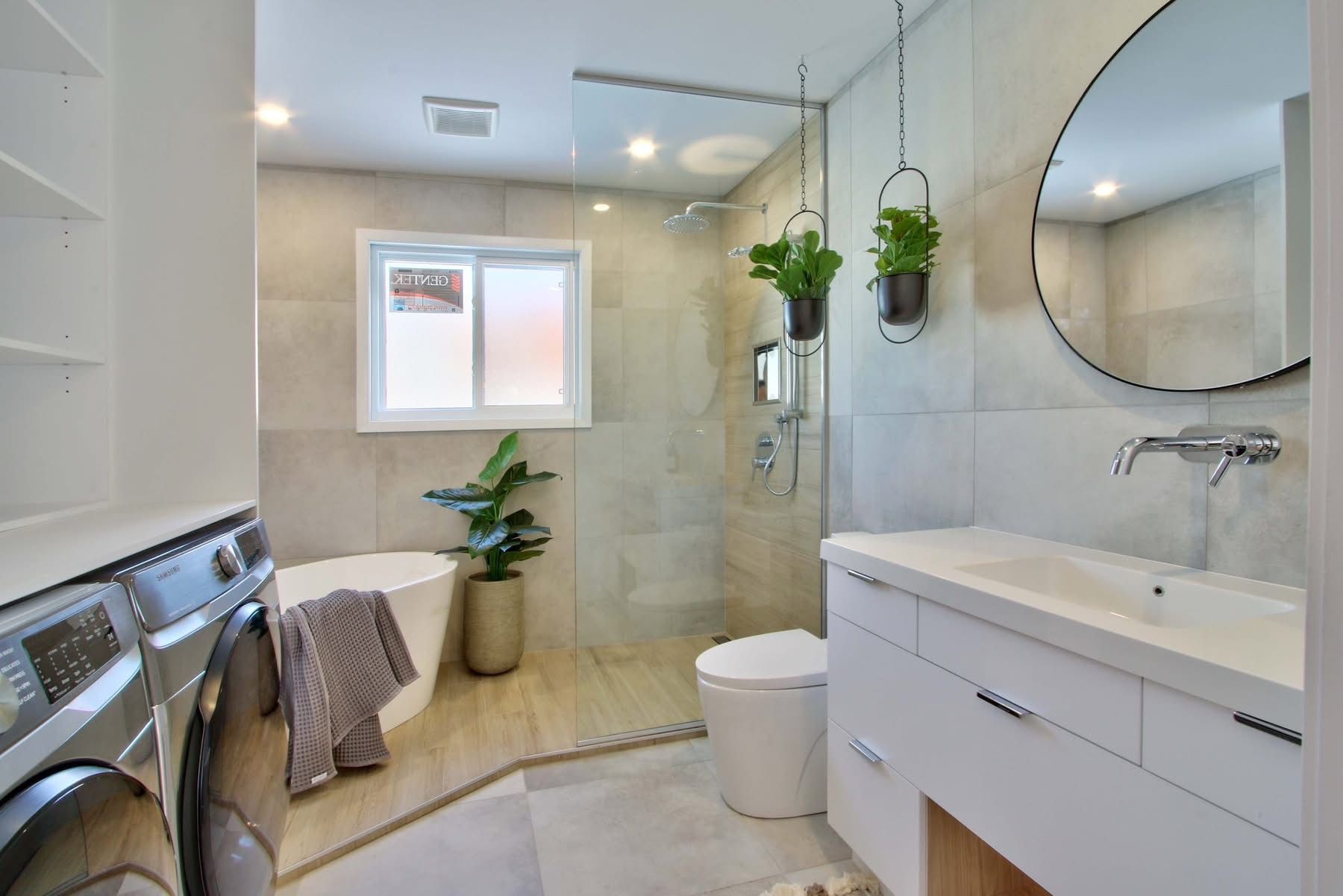 Une salle de bain avec baignoire, WC, lavabo et miroir.