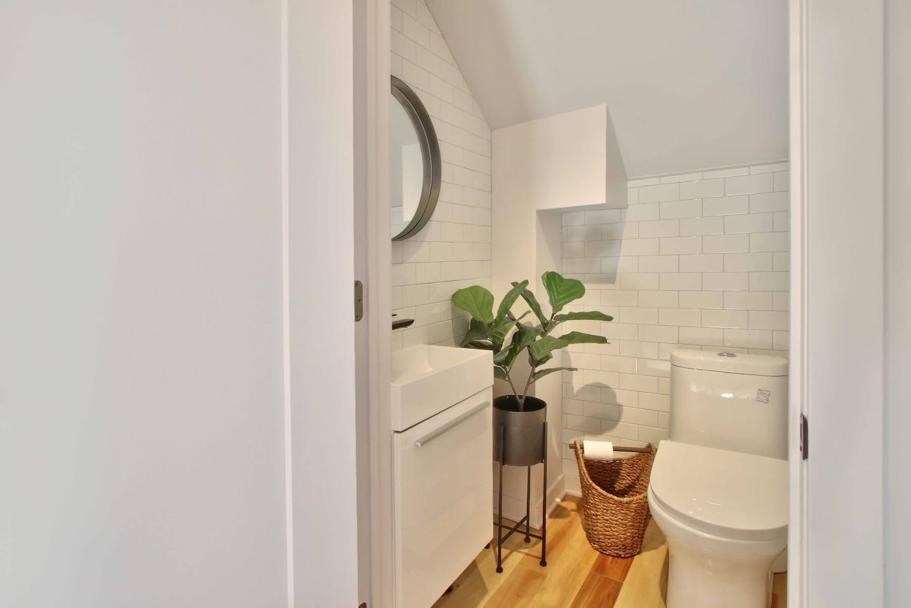 Une salle de bain avec WC, lavabo et miroir.