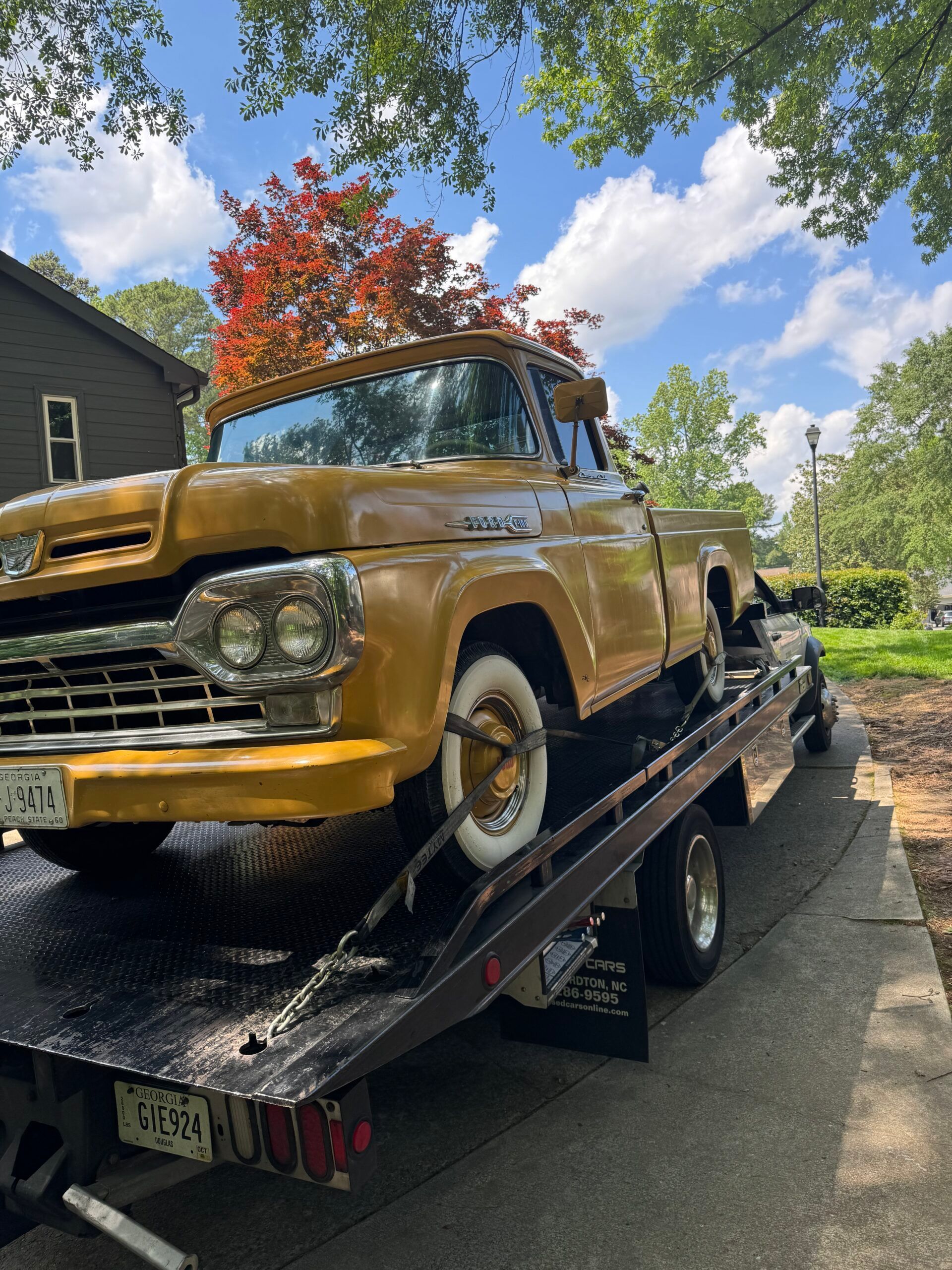 A yellow truck is being towed by a tow truck.
