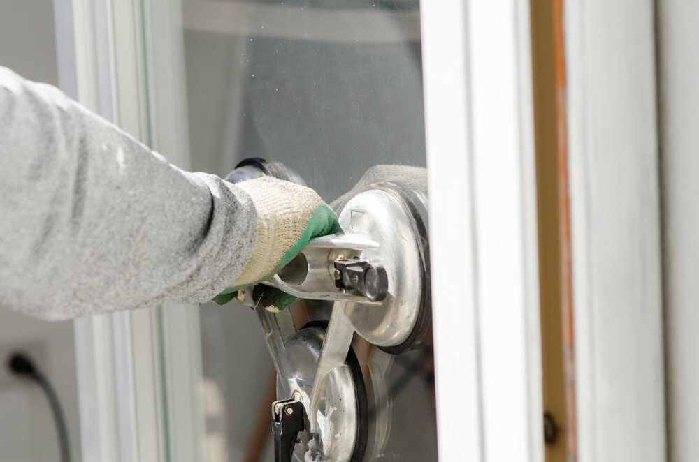 Gloved Hand Using a Suction Cup to Remove a Glass Pane From a Window Frame — ACG Windows & Glass in Lyndhurst, VIC