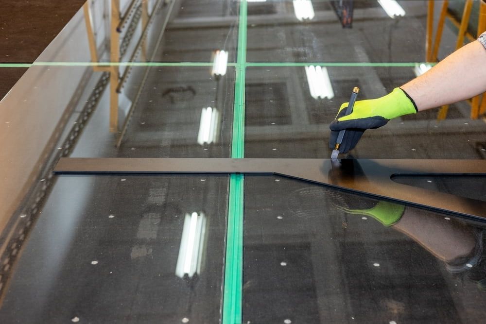 A Worker Wearing Lime Green Gloves Uses a Black Cutting Tool — ACG Windows & Glass in Narre Warren, VIC