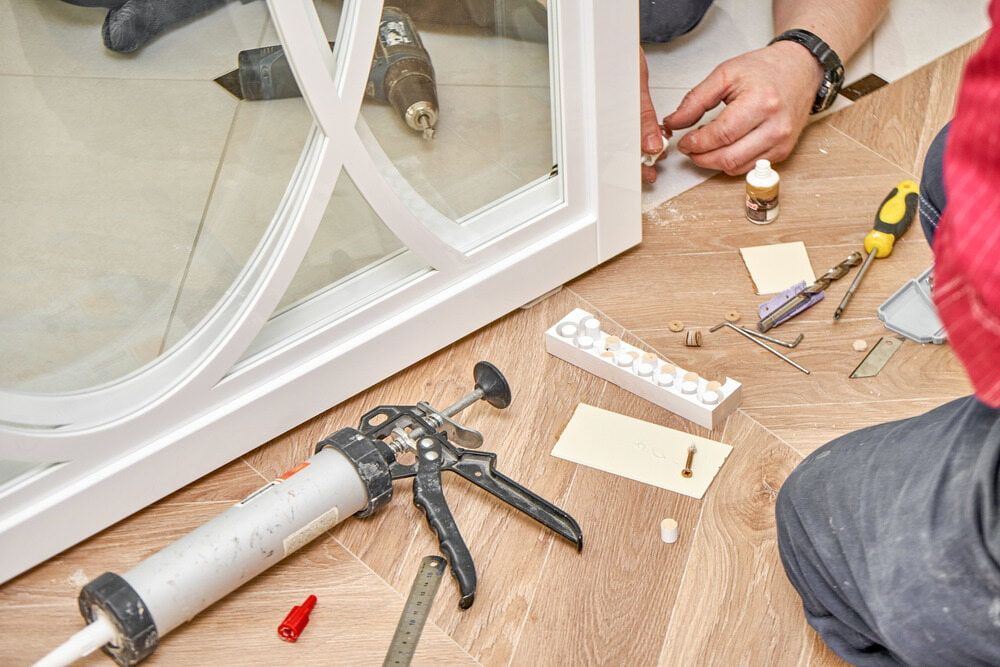 A Worker Installs a White-framed Glass Door — ACG Windows & Glass in Officer, VIC
