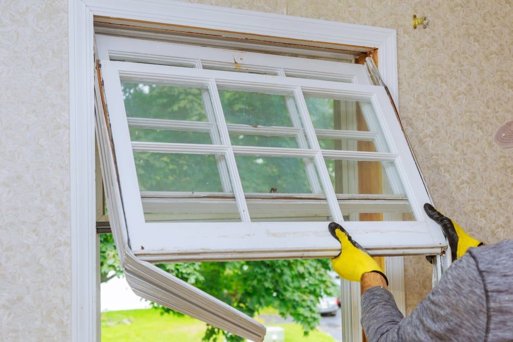 A Person Wearing Yellow Work Gloves Installs a White, Multi-pane Window — ACG Windows & Glass in Latrobe Valley, VIC