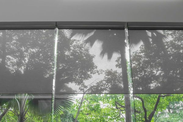 Three Grey Roller Shades Partially Covering a Large Window — ACG Windows & Glass in Lyndhurst, VIC