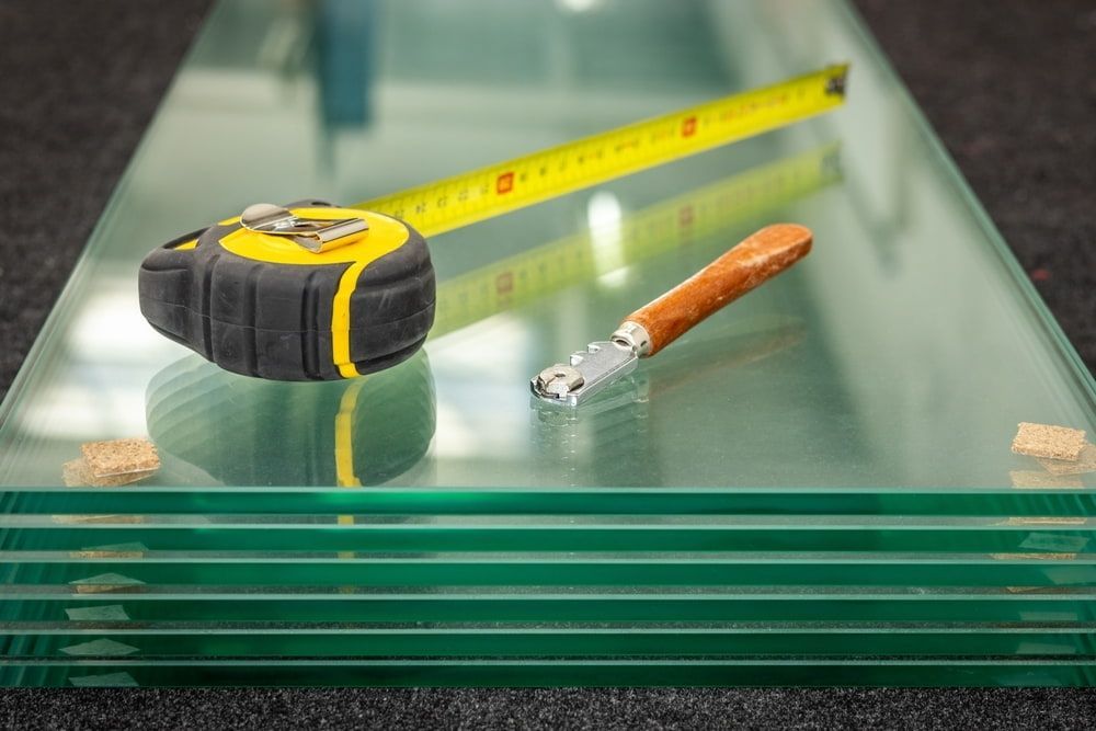 A Yellow Tape Measure and a Glass Cutter — ACG Windows & Glass in Seaford, VIC