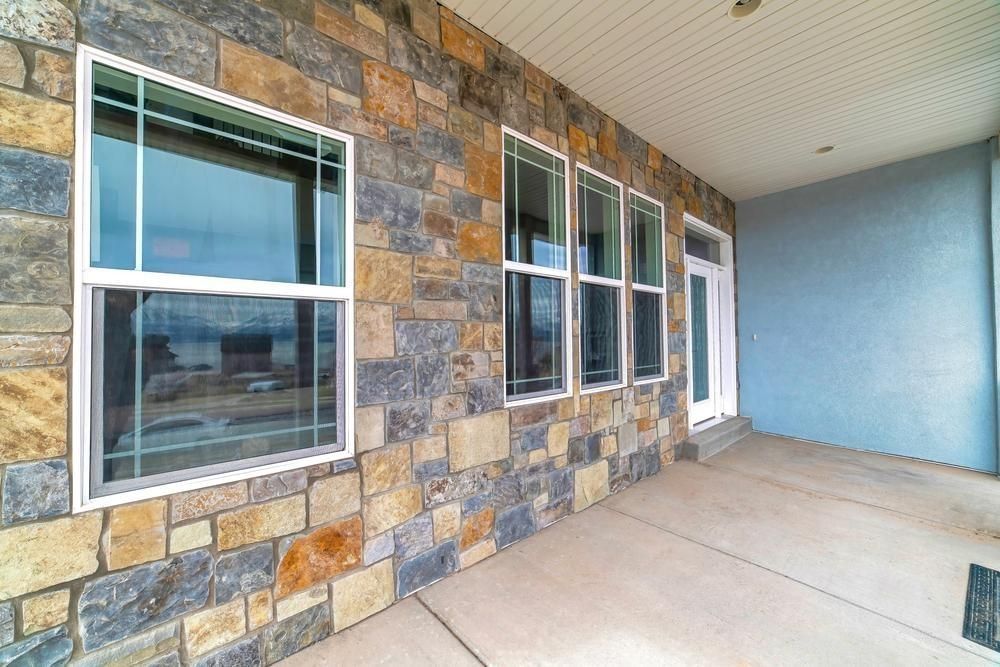 Stone-faced building entrance with windows, white door, and covered concrete walkway — ACG Windows & Glass in Chelsea, VIC