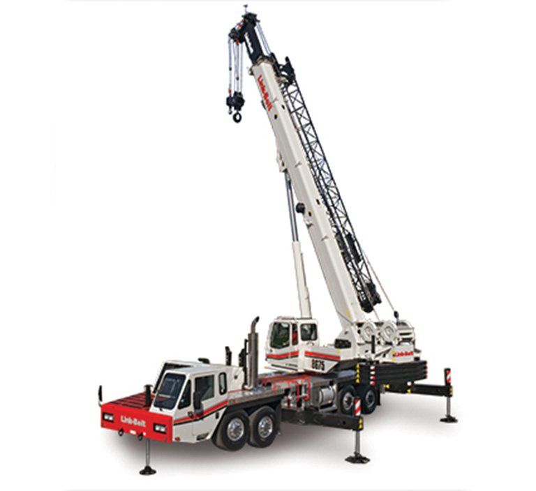 White and red mobile crane with extended boom and outriggers, parked outdoors.