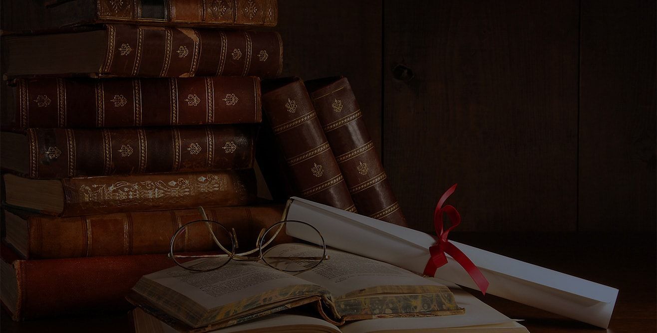 A stack of old books sitting on top of each other on a wooden table.